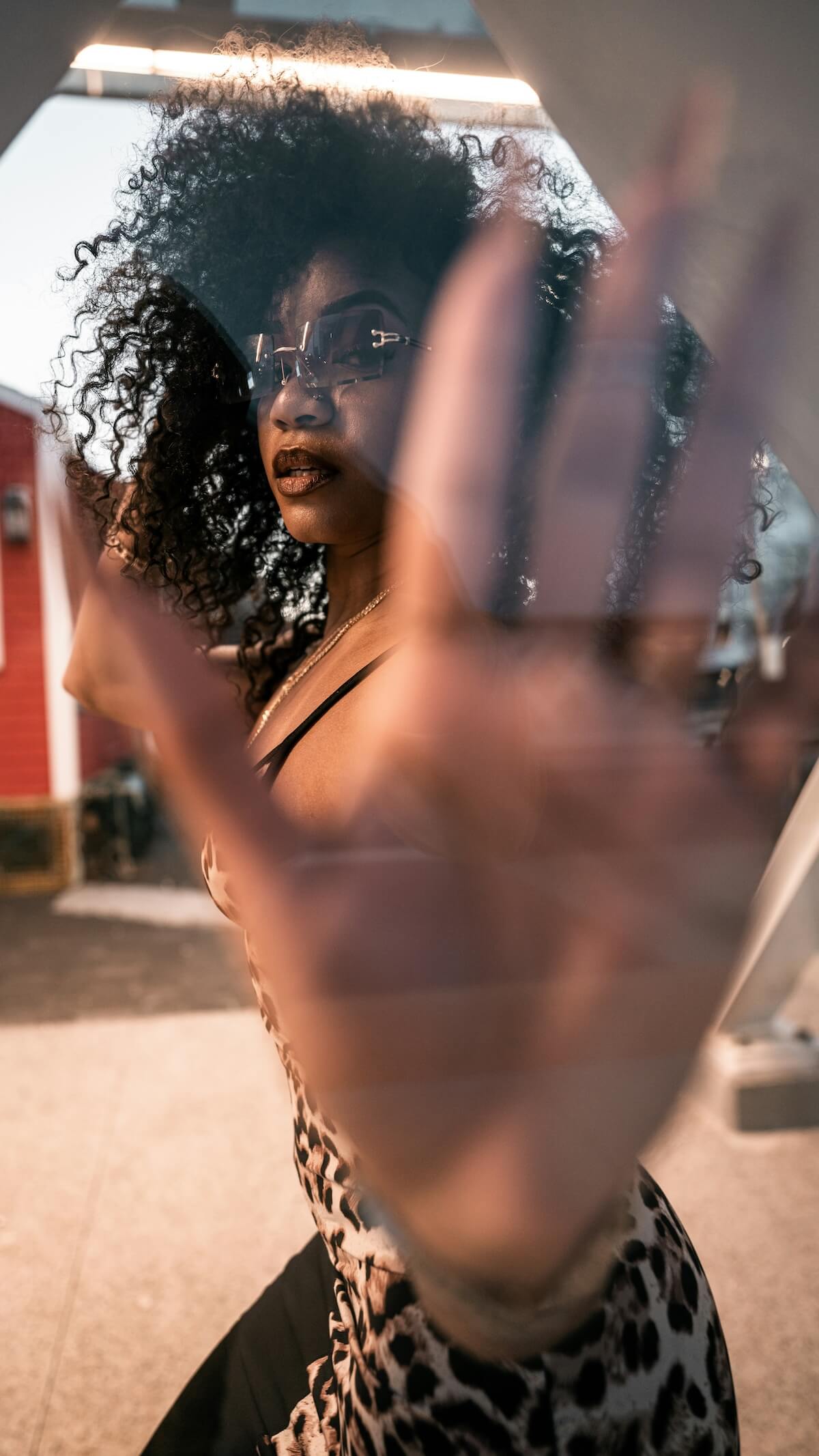Unsplash: Woman with curly hair and palm to camera by Raul de Los Santos