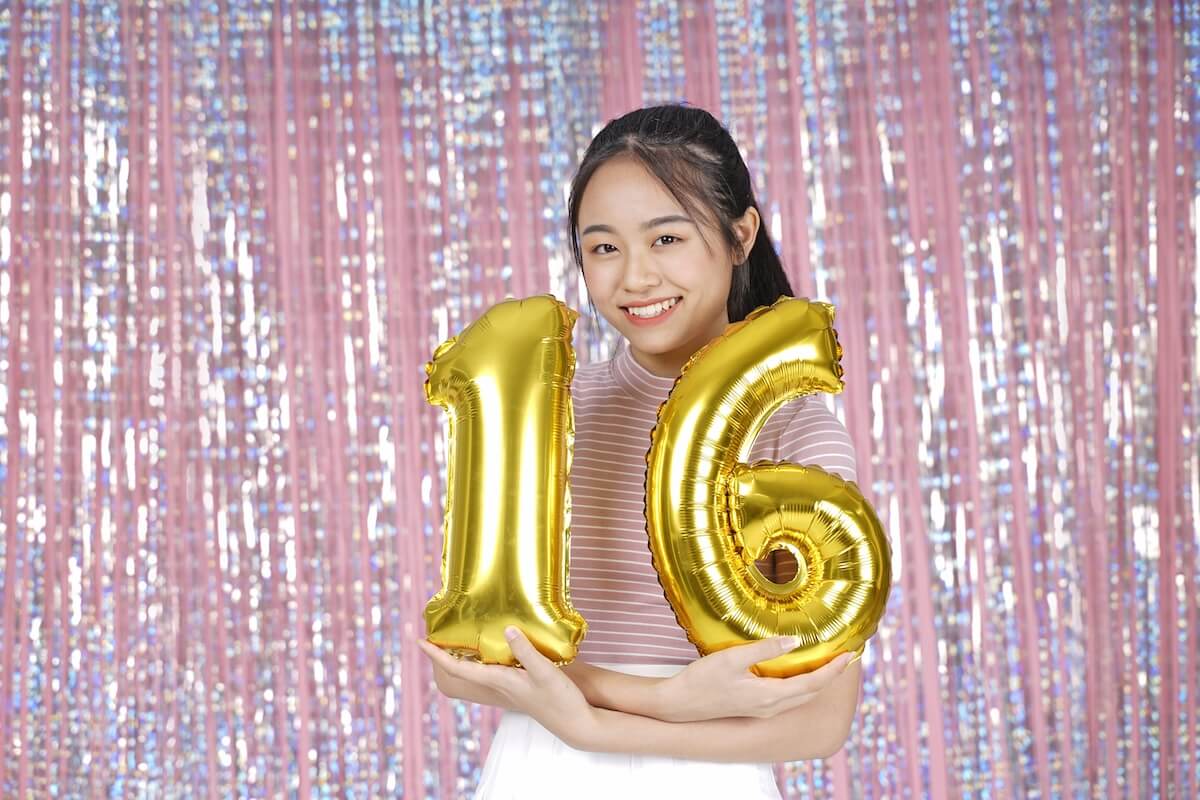 Shutterstock: Asian young teenager pretty cheerful beautiful girl with party gold foil balloon, on pink sparkling background