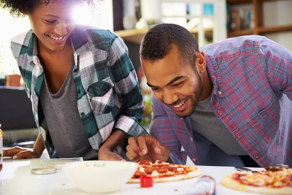 Shutterstock Couple making homemade pizzas Young Couple Making Pizza In Kitchen Together