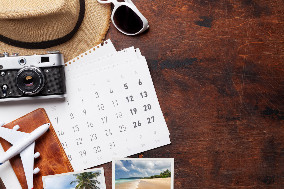 Shutterstock: Travel vacation background concept with calendar, sun hat, camera, passport, airplane toy and weekend photos on wooden backdrop. Top view with copy space. Flat lay. All photos taken by me
