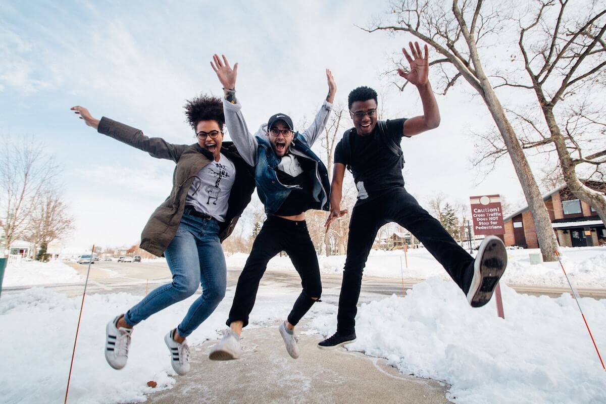 Unsplash three best friends laughing jumping over snow zachary nelson