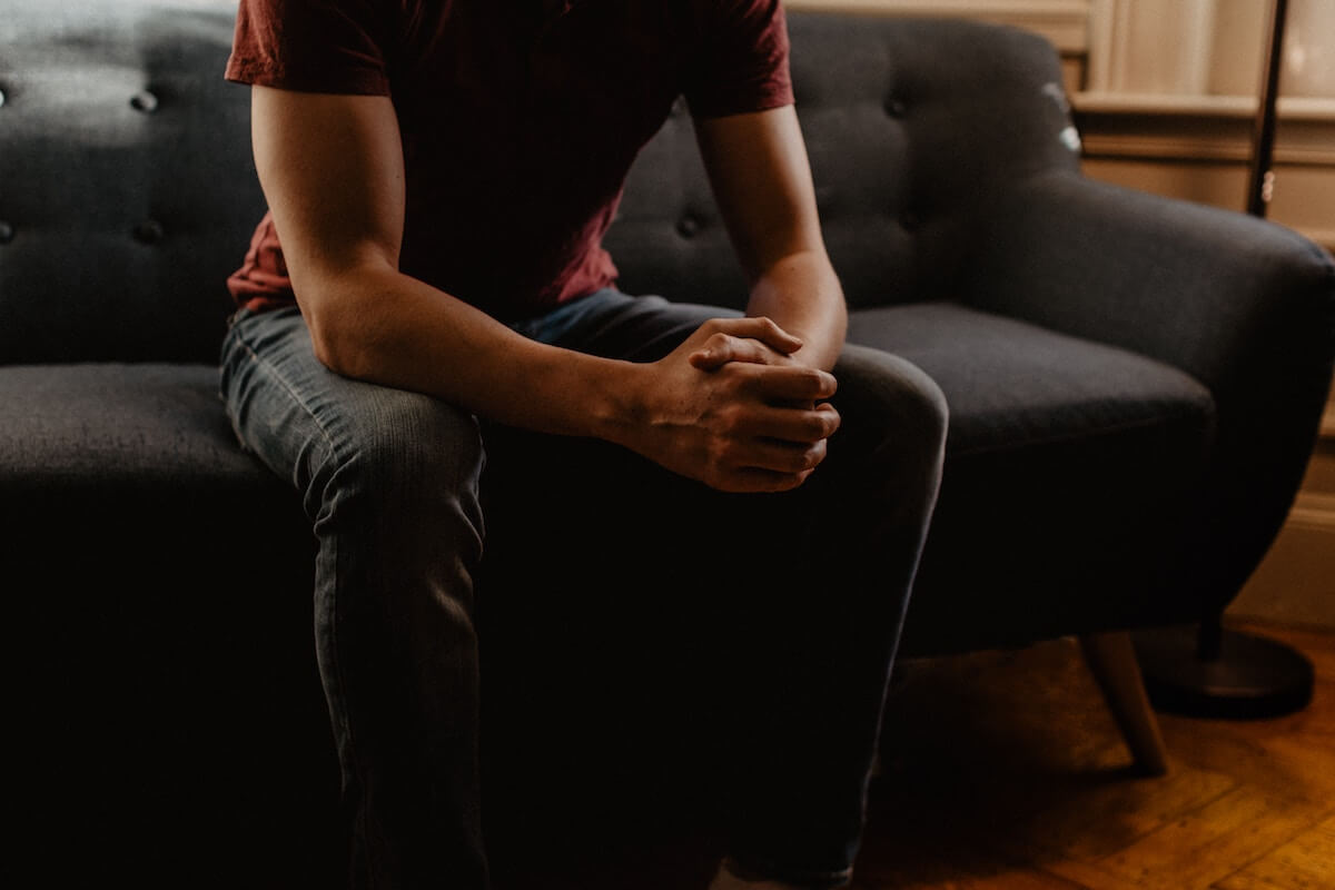 Unsplash: Man sitting on couch explaining by Kelly Sikkema