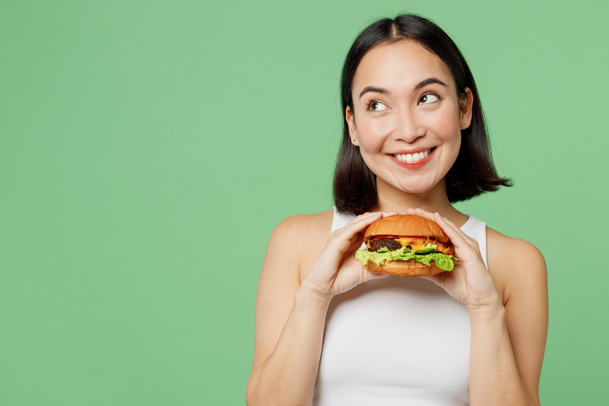 a young woman enjoying a burger