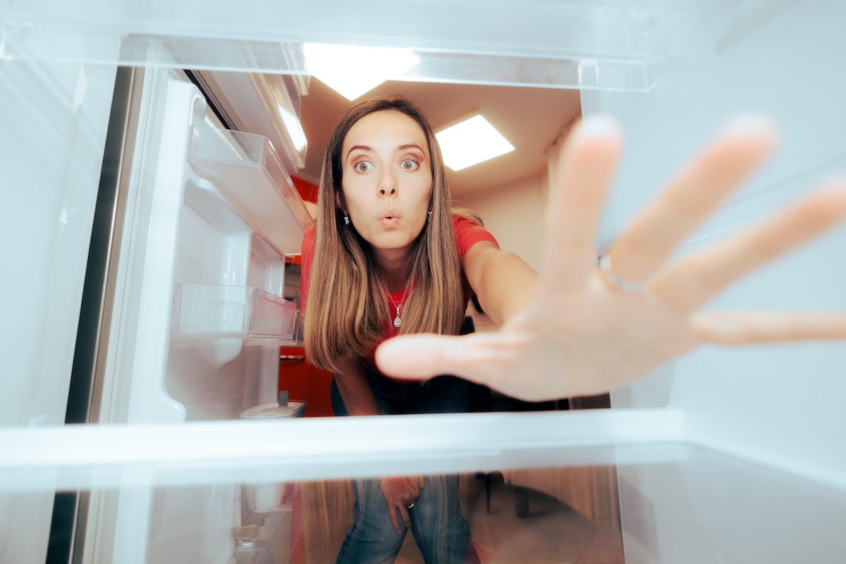 Shutterstock: Hungry woman reaching into fridge perspective