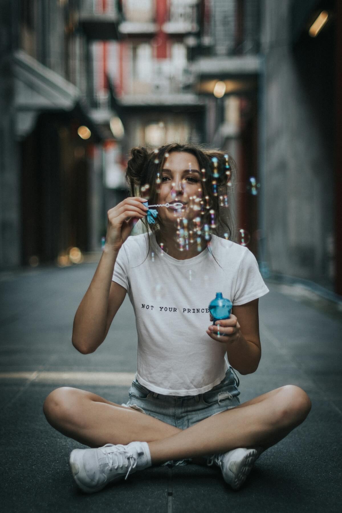 Unsplash: Woman playfully blowing bubbles by Joshua Rawson Harris