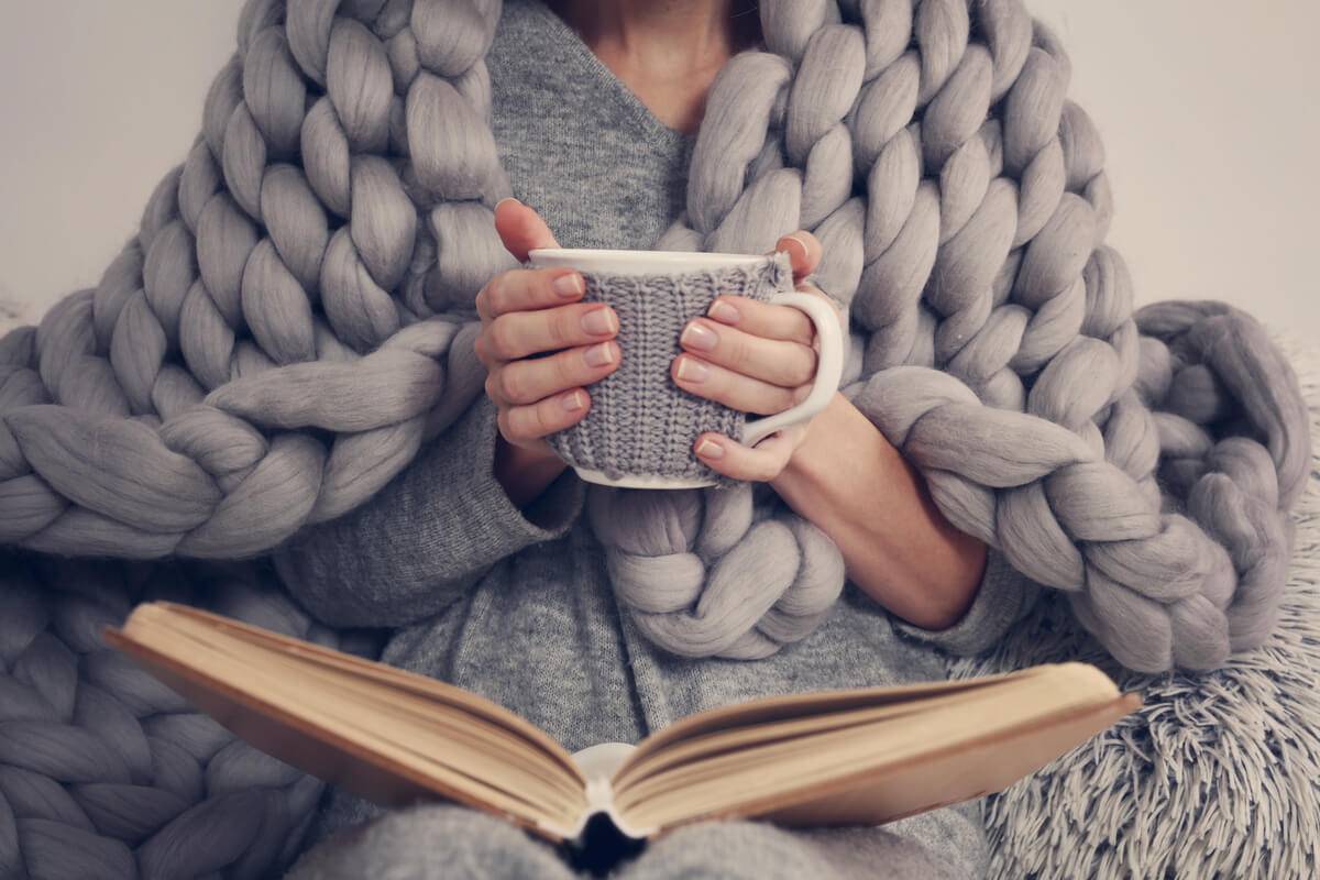 woman reading with a cup of hot cocoa