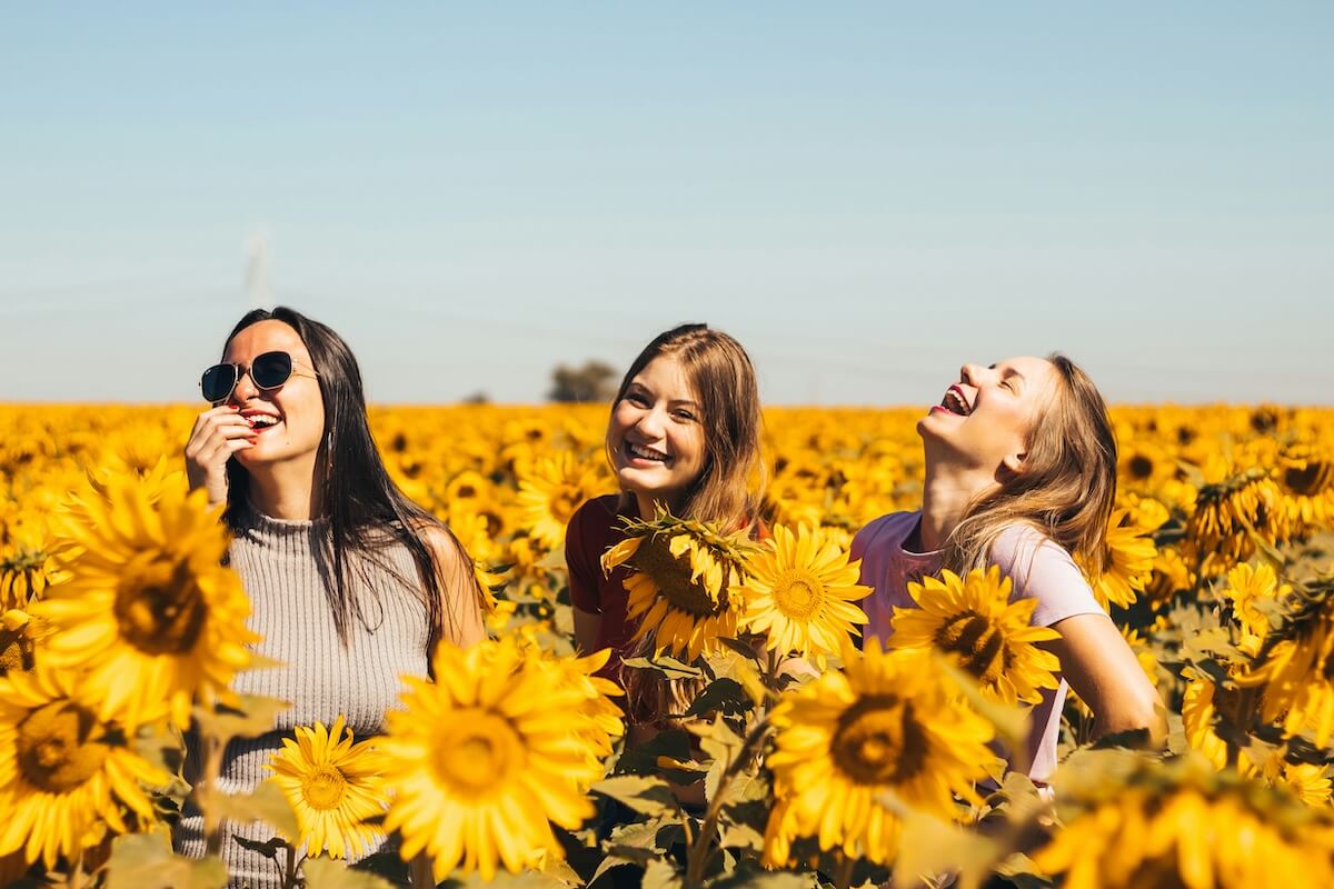 Unsplash: Friends smiling in sunflower patch by Antonino Visalli