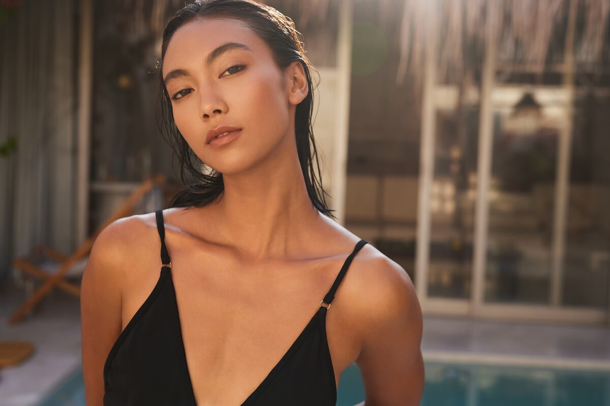 Shutterstock: Confident fashion. Woman In Swimsuit By Poolside, Elegant Tropical Resort Setting