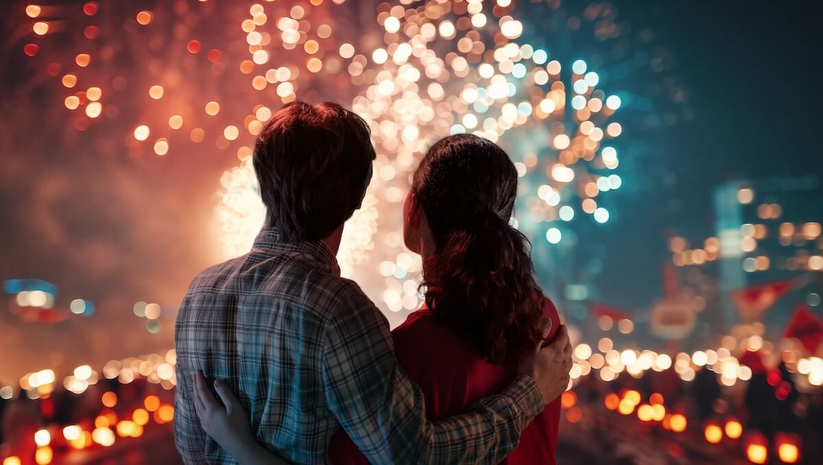 Shutterstock: Happy loving couple watching fireworks.