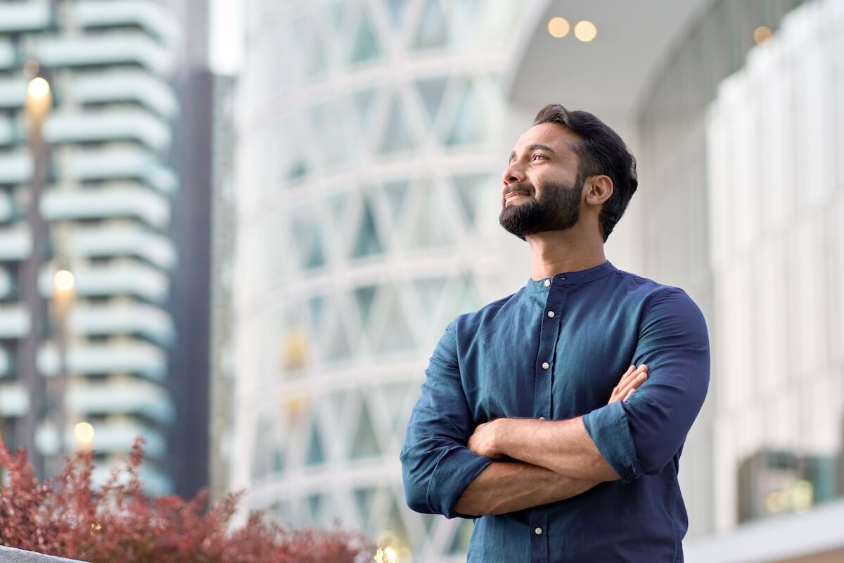 Shutterstock: Confident rich eastern indian business man executive standing in modern big city looking and dreaming of future business success, thinking of new goals, business vision and leadership concept.