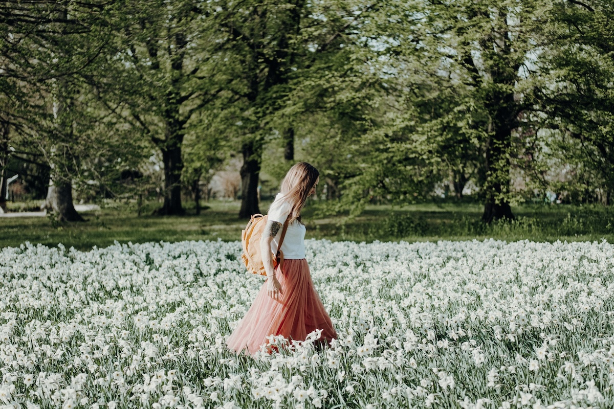 Unsplash: Woman walking through white flower field by Nadine Rupprecht