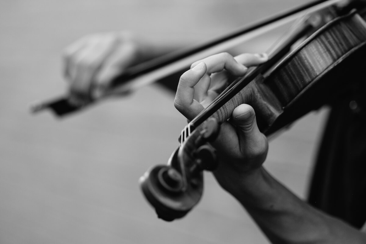 Unsplash: Black and white hands playing violin by Joel Timothy