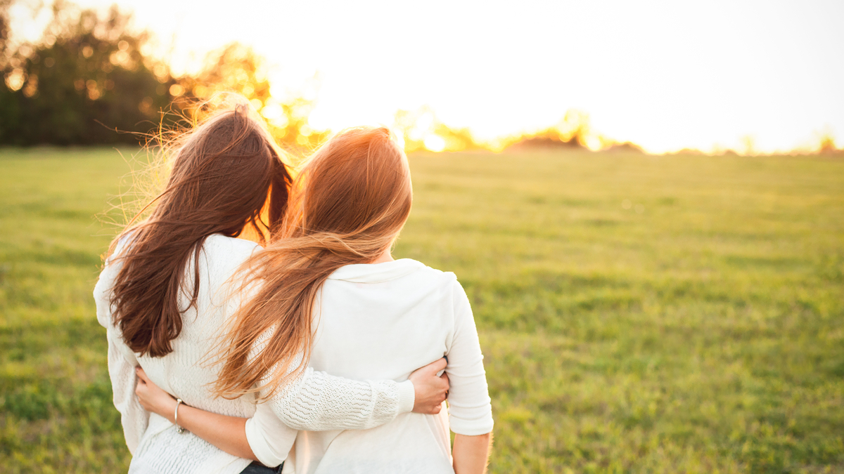 friends hugging in grass
