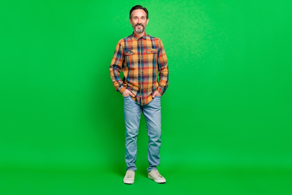 Shutterstock: Full length body size view of attractive cheerful man holding hands in pockets isolated over bright green color background