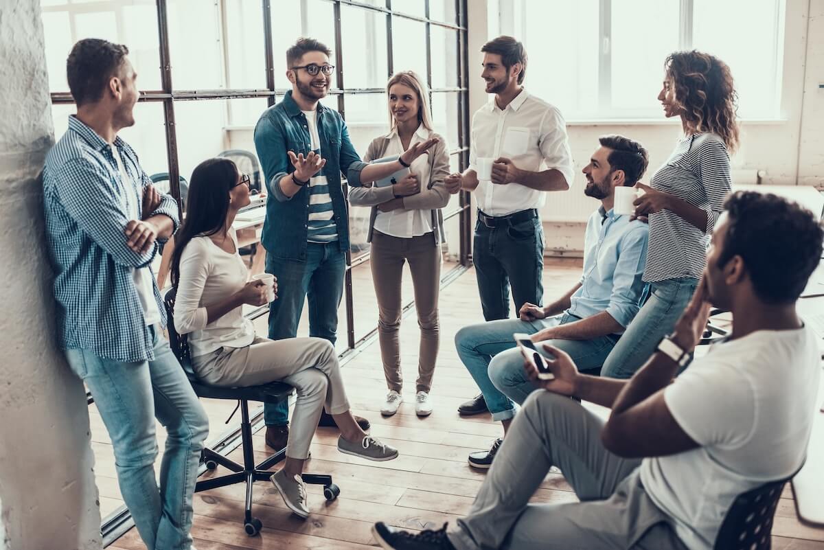 Shutterstock: Group of Young Business People on Break in Office. Successful Business Team Talking on Coffee Break. Young Smiling Colleagues on Break Drinking Coffee Chatting in Modern Office. Corporate Lifestyle