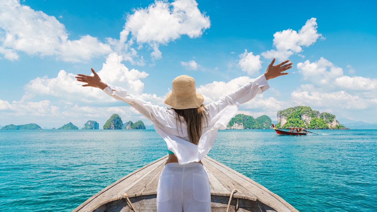 Shutterstock: Happy traveler woman on boat joy fun nature panoramic view group of small island Andaman sea Krabi, Freedom adventure travel Phuket Thailand summer holiday vacation trips, Tourism destination Asia
