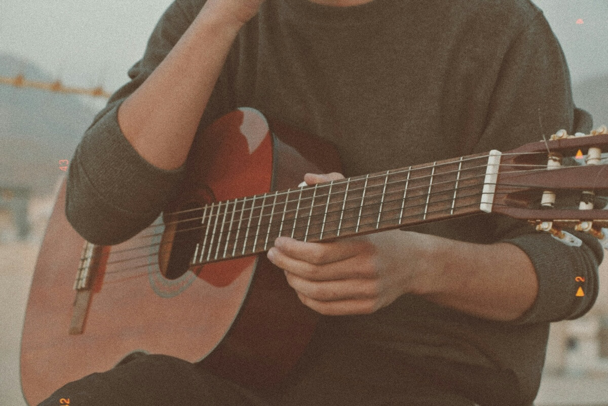 Unsplash: Person playing guitar outside by Mahyar Mirghasemi