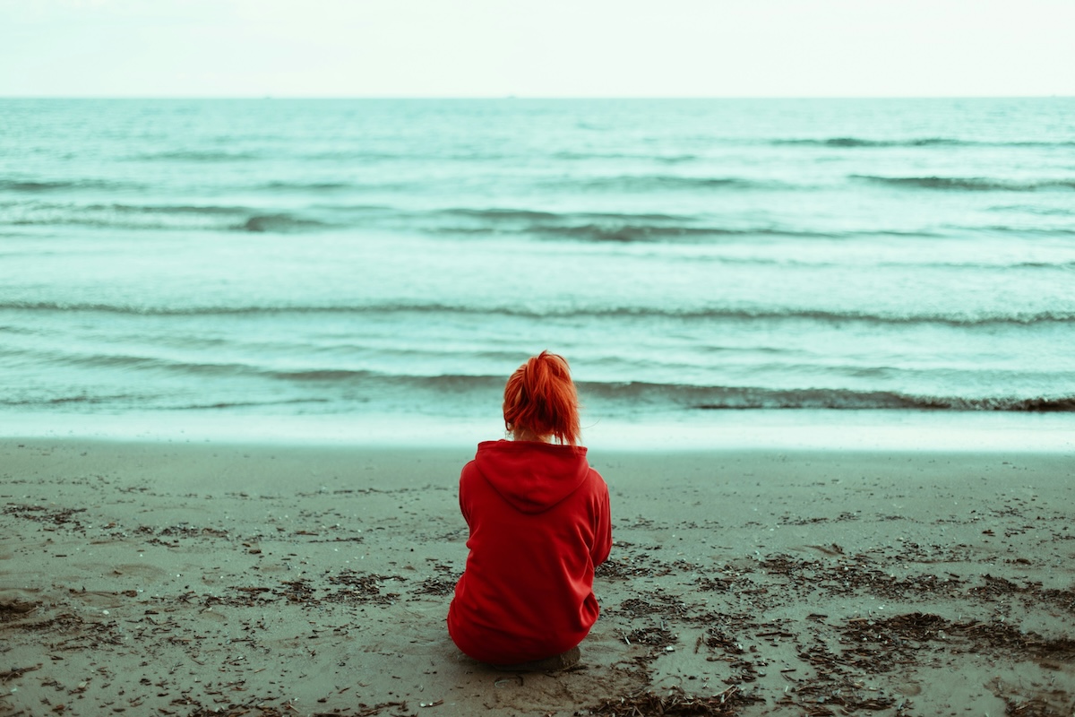 Unsplash: Woman sitting on beach near water by Ahtziri Lagarde