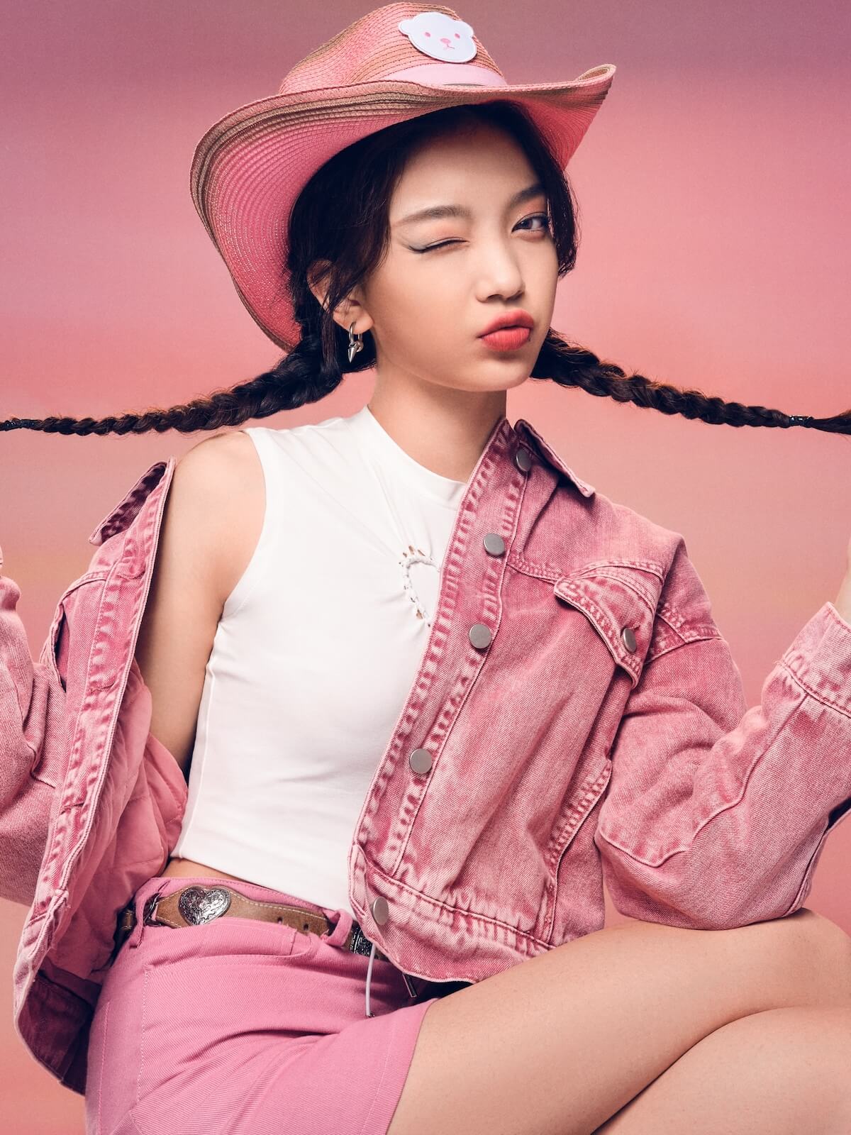 Shutterstock: Trendy Young Woman in Pink Denim and Hat Striking a Playful Pose on a Vibrant Background - Fashionable Youthful Style and Attitude.