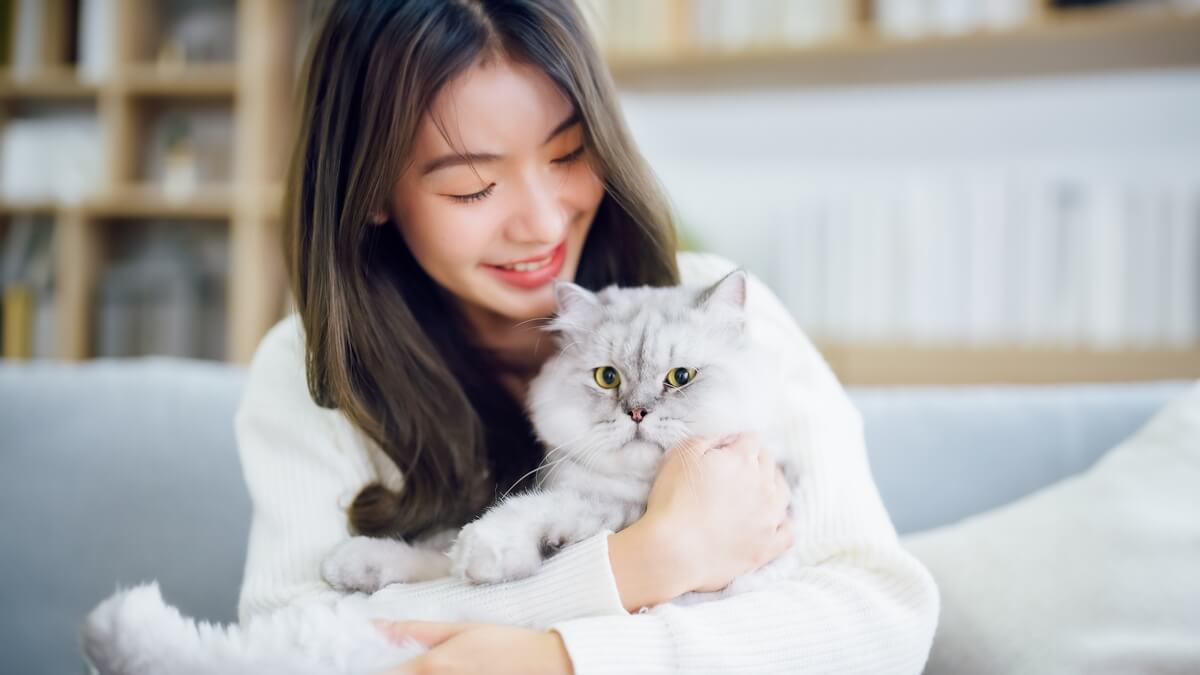 woman snuggling with cat