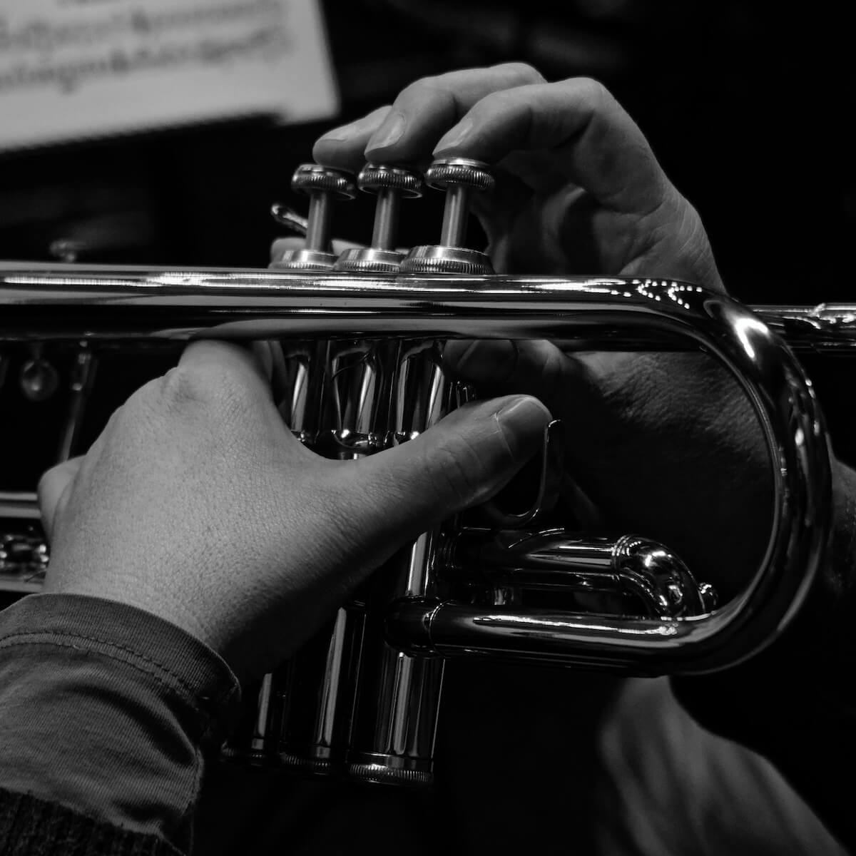 Unsplash: Close up of hands on trumpey by Gilles Gravier