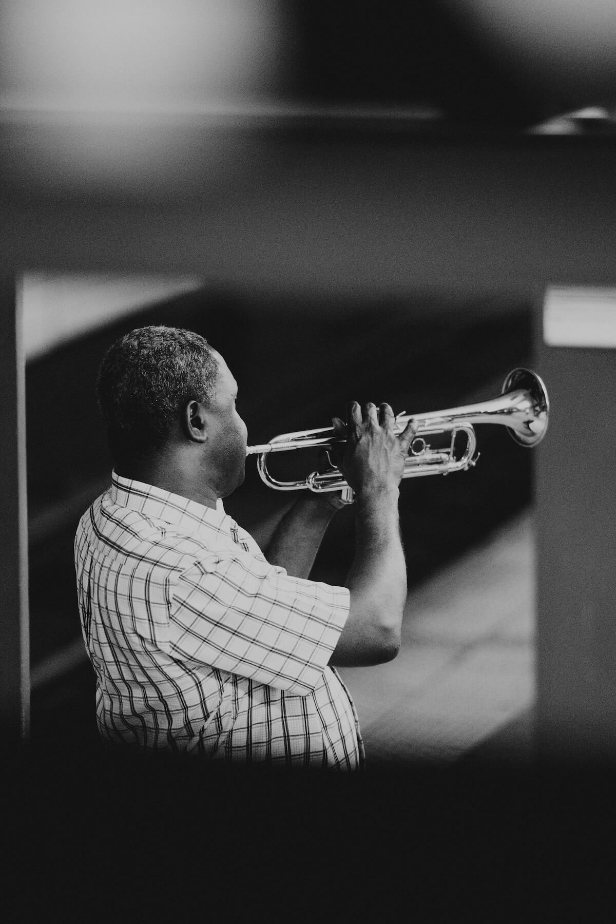Unsplash: Man playing trumpet in black and white by Ryan loughlin
