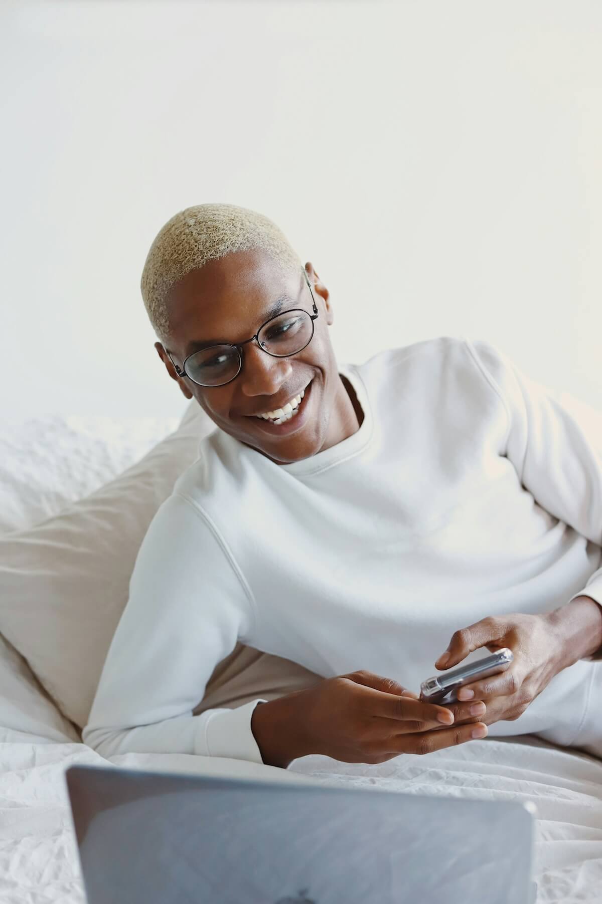 Unsplash: Man smiling holding phone by Good Faces