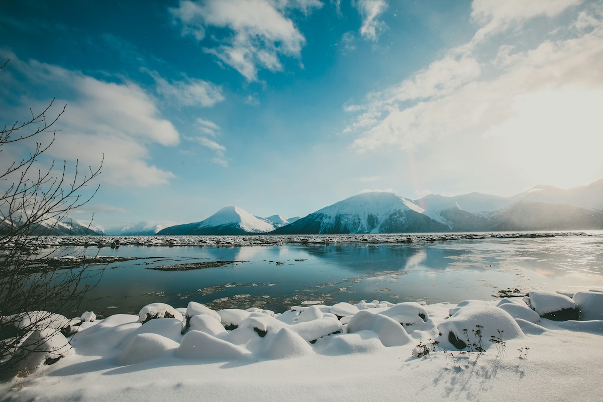 Unsplash: Alaskan snowy mountains over clear blue waters by Rod Long