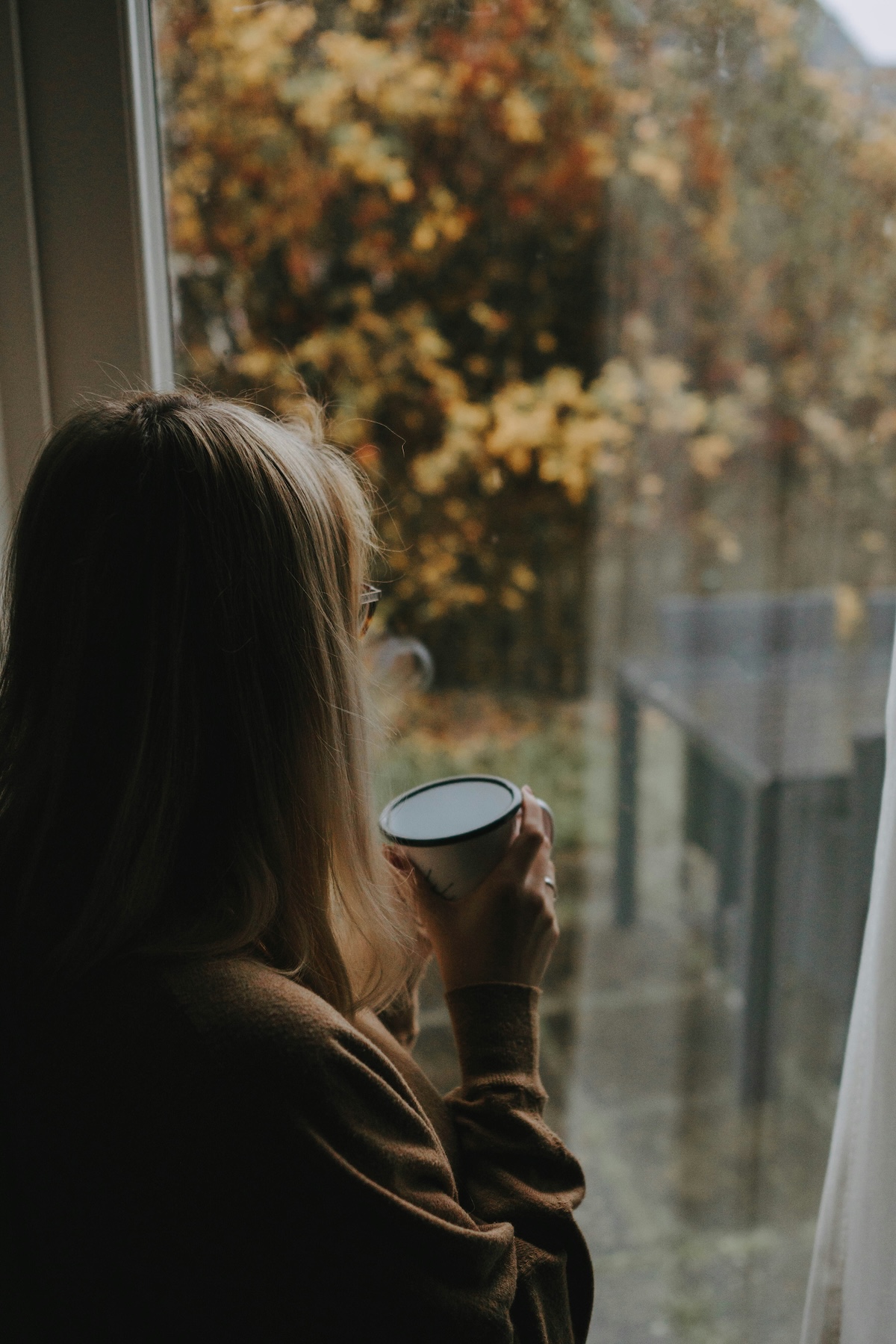 Unsplash: Woman looking outside window bored by Patrik Laszlo
