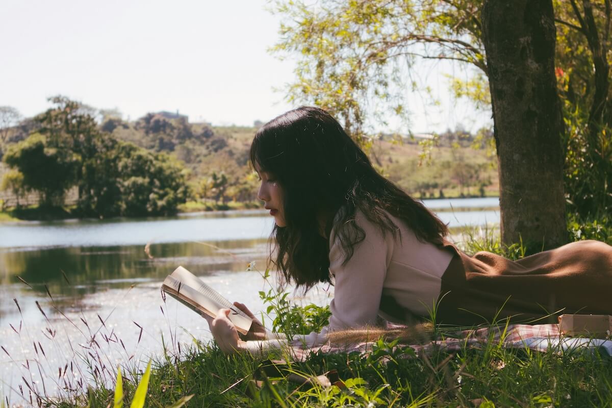 Unsplash: Woman reading by water by nguyen thu hoai