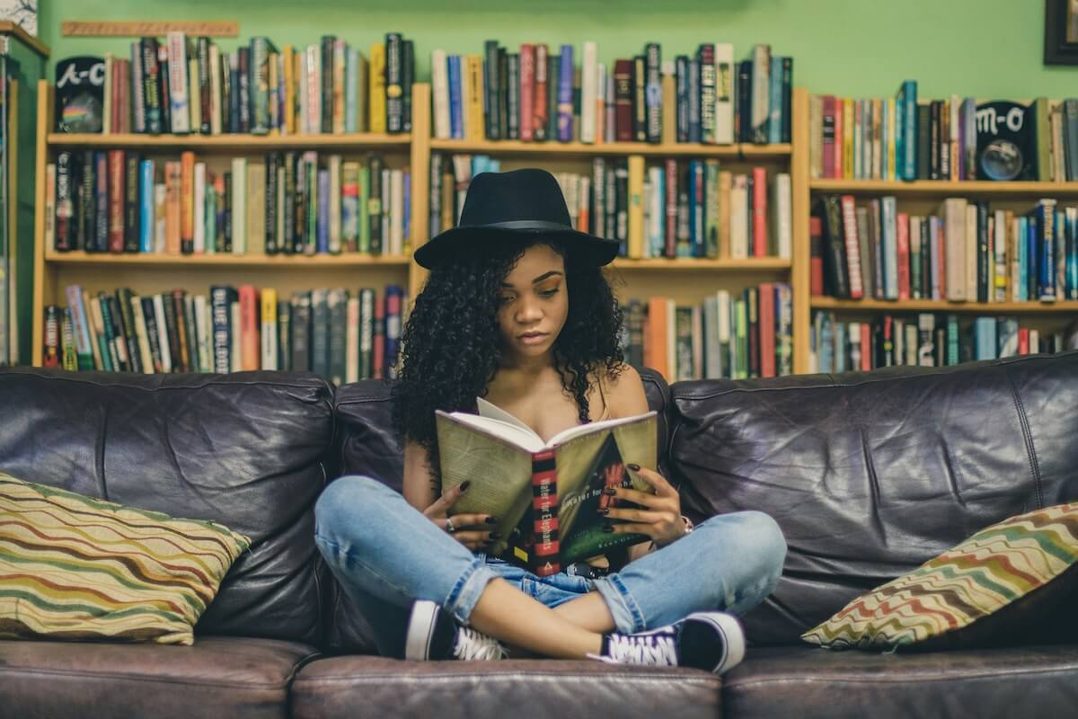 Unsplash: Woman reading on library couch by Seven Shooter