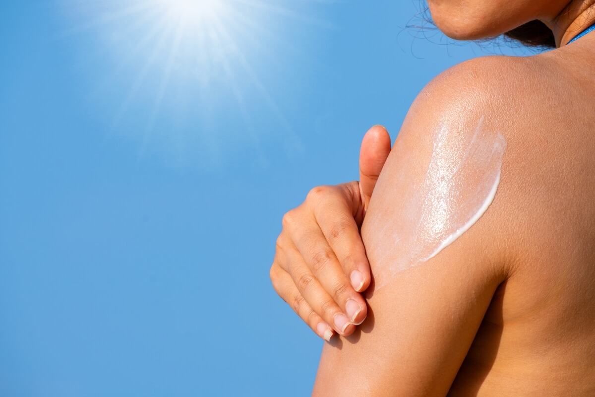 woman applying sunscreen to body