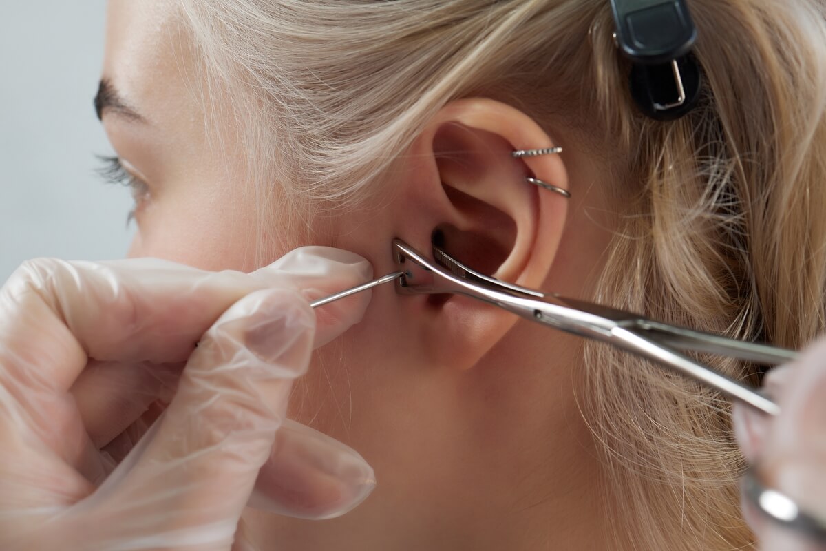 woman getting ear pierced