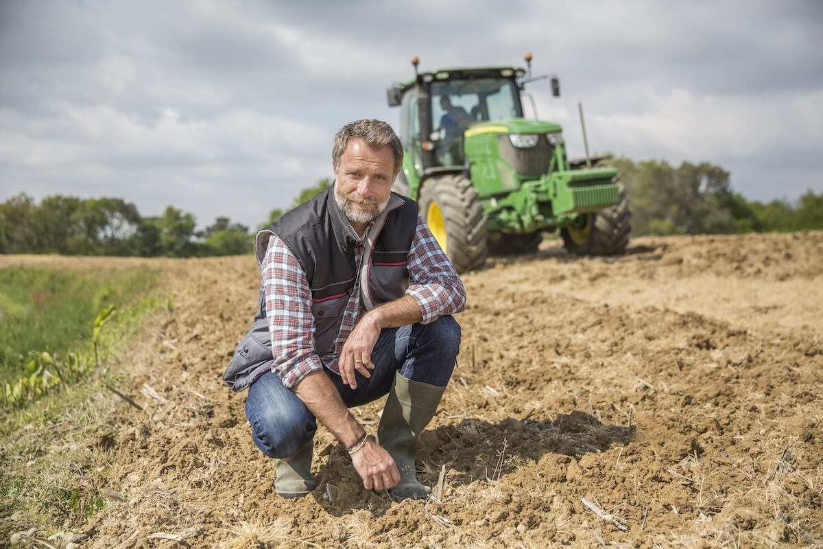 Shutterstock: farmer examine quality of soil in field