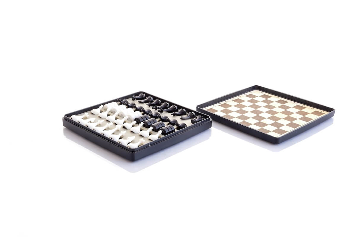 Shutterstock: Old travel kit. Pocket chess and checkers in a case with a magnetic board. Closeup image on a white background. Deep depth of field, image in focus from front to back.