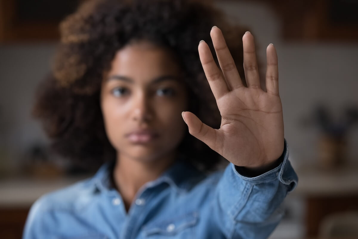 Shutterstock: Close up focus African woman show palm hand opposes racial or gender discrimination, make stop gesture, sign of protest, female against domestic violence, abortion, bullying at school, say no concept