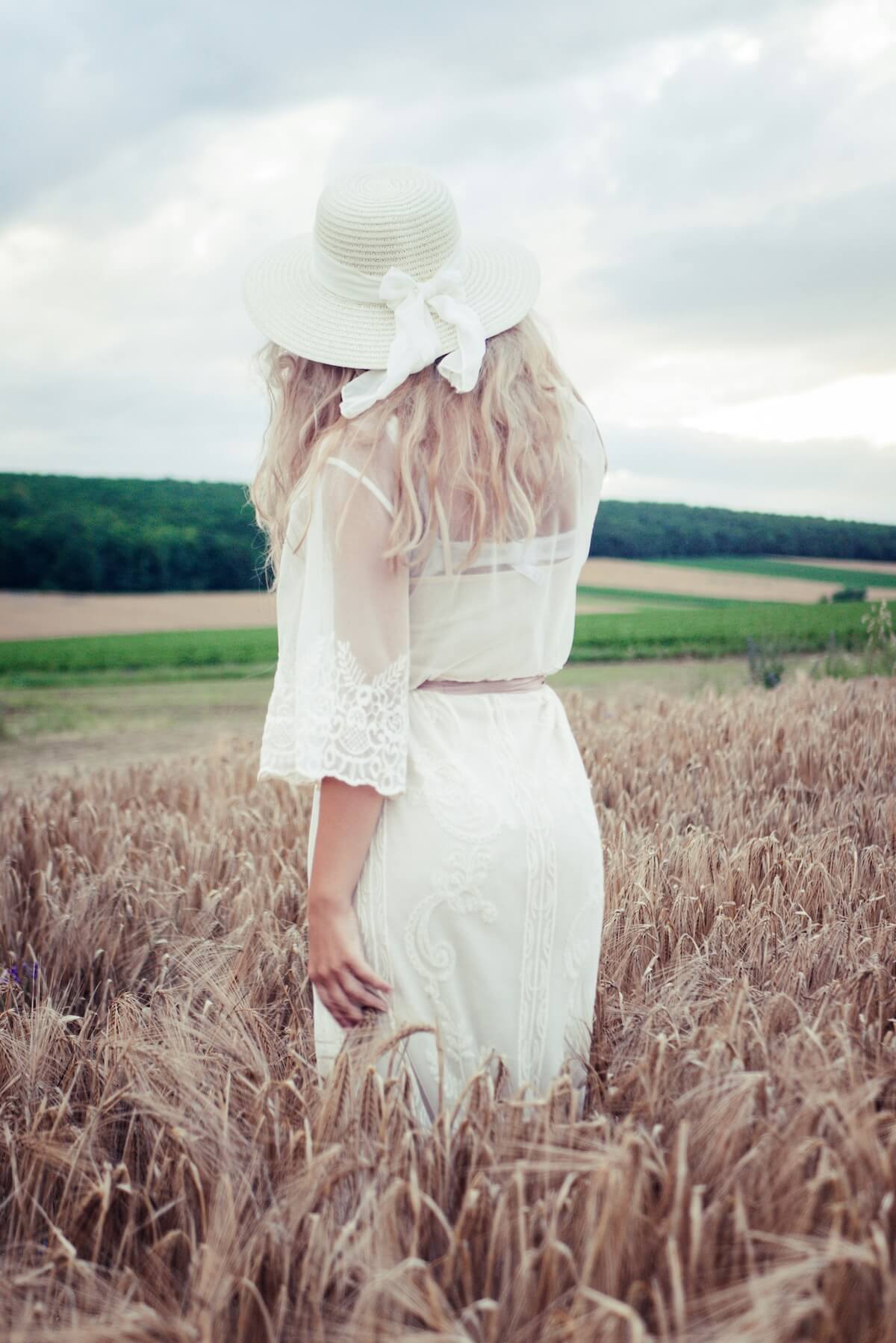 Unsplash: Woman in white top, skirt and hat by Manu B