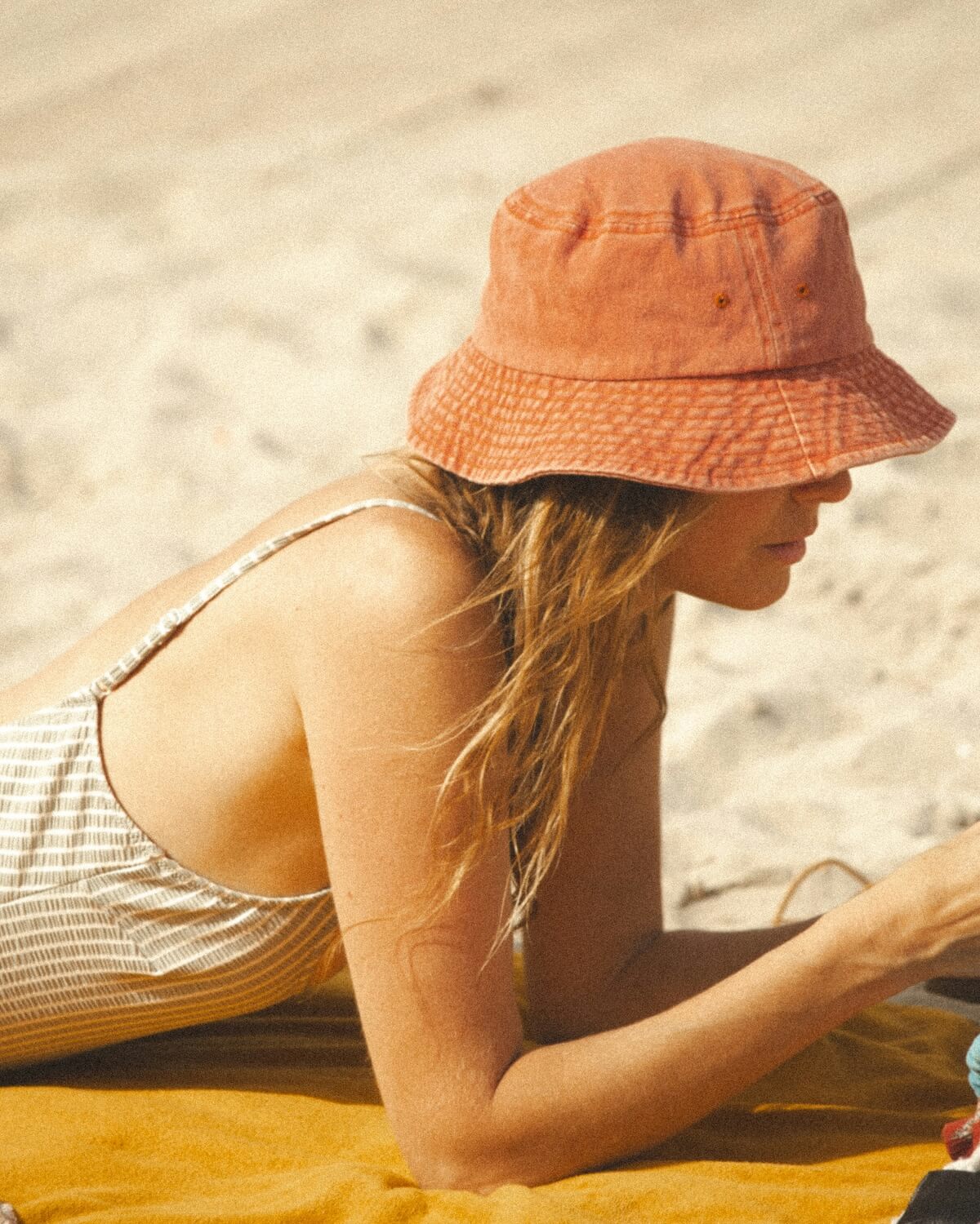 Unsplash: Woman on beach in the sand with phone by Raymond Petrik