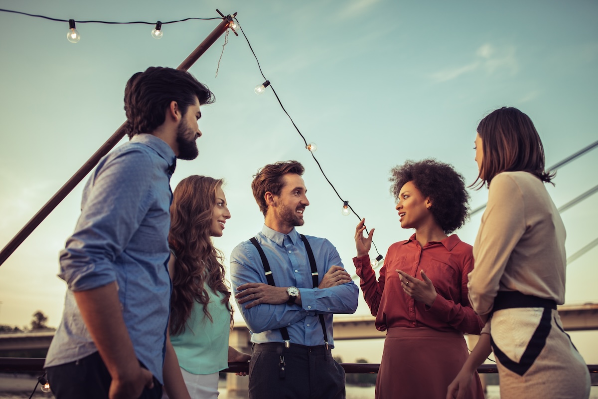Shutterstock: Cropped shot of a group of friends having a conversation on a boat