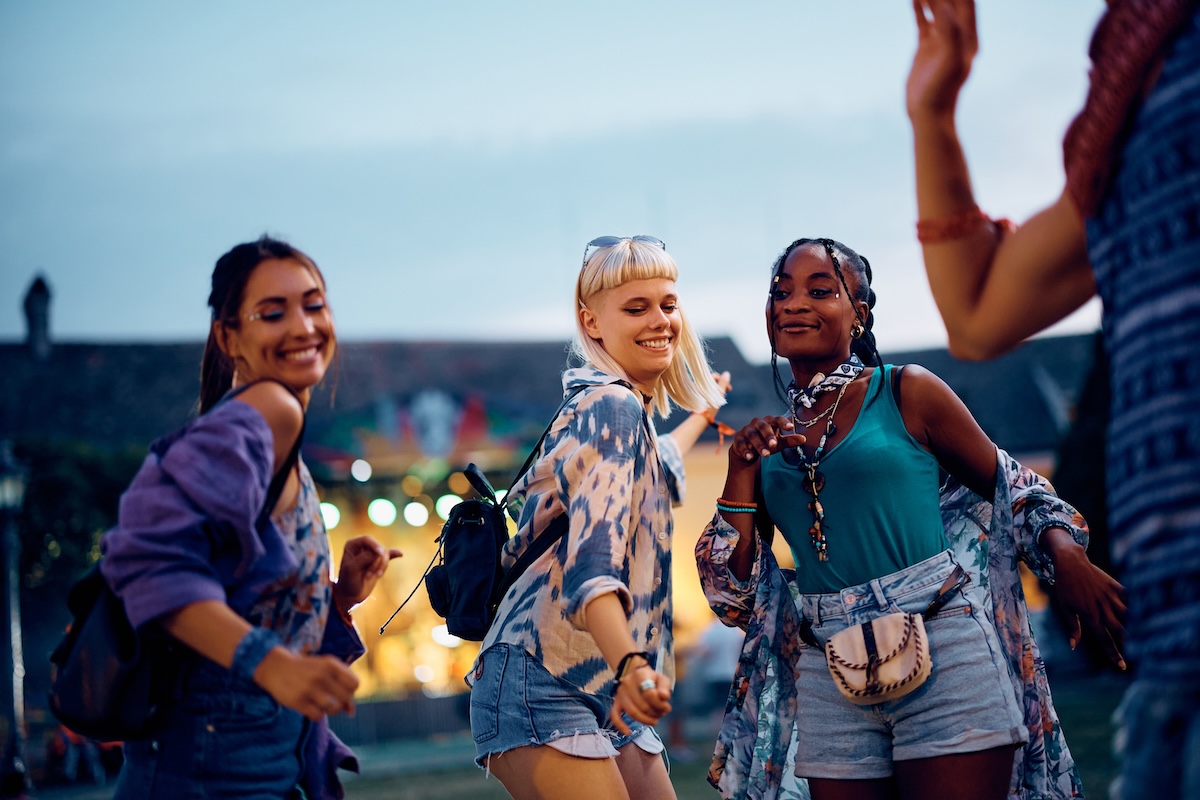 Shutterstock: Group of carefree friends having fun and dancing at summer music festival.