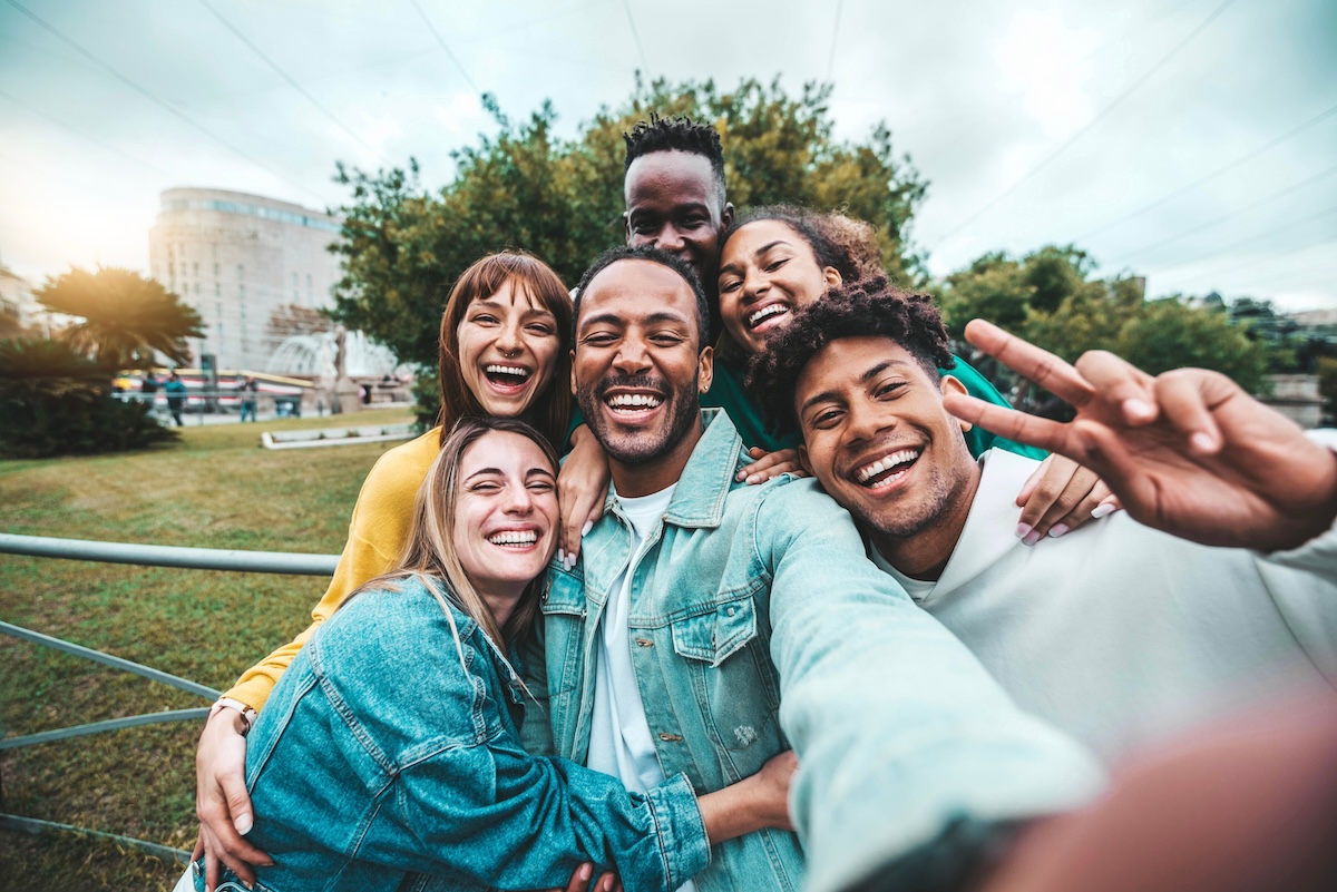 Shutterstock: Multicultural friends taking selfie picture outside - Happy young people having fun walking on city street - Friendship concept with teenagers laughing at camera