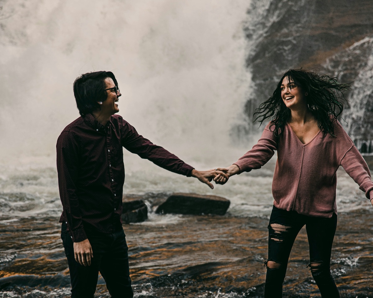 Unsplash: Couple on outdoor adventure near waterfall by Tabitha Turner