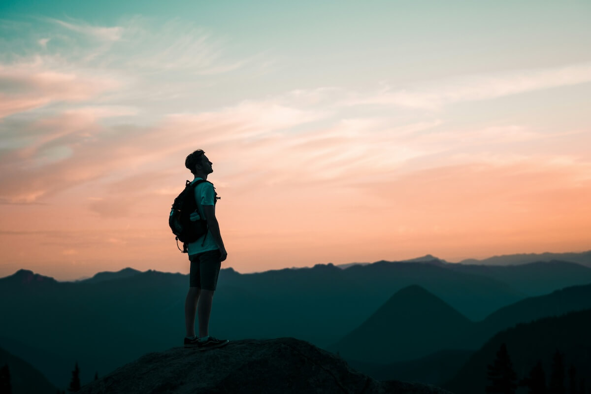 Unsplash: Man backpacking and hiking at sunset by Ben Dutton