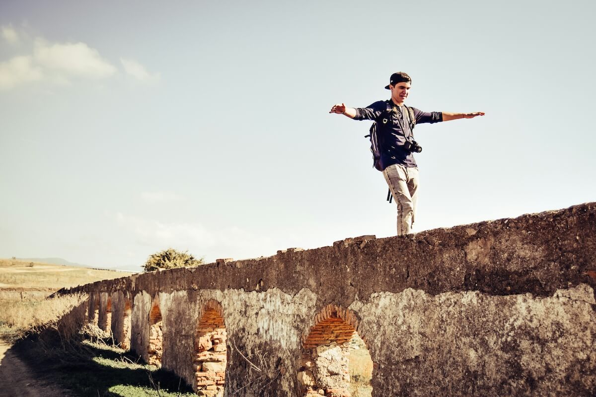 Unsplash: Man balancing on an old bridge by Pablo Guerrero