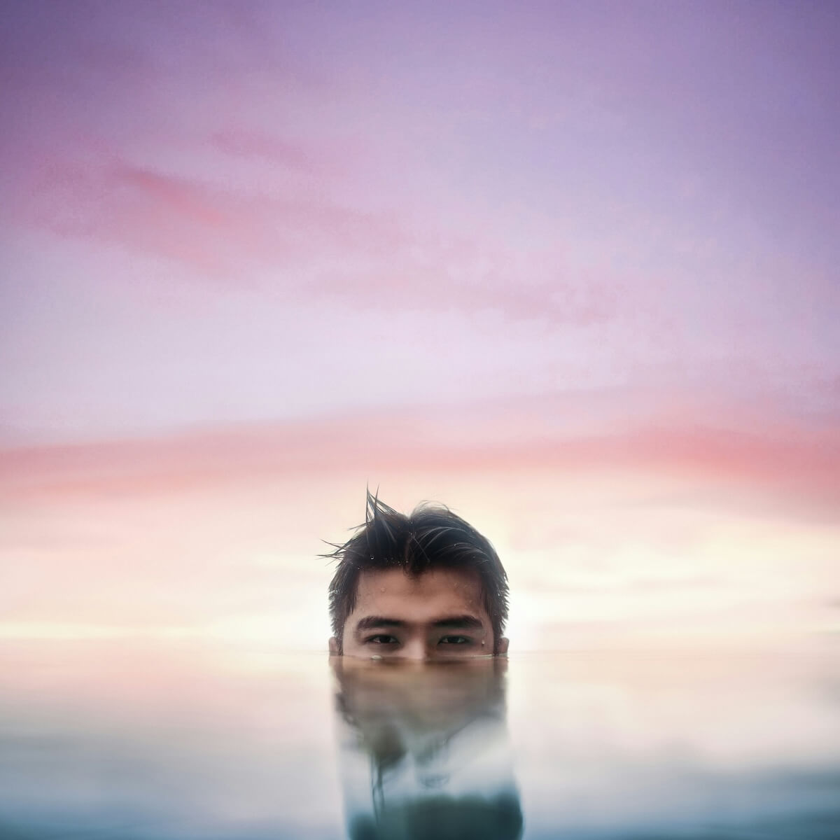 Unsplash: submerged man against sunset by marty garcia