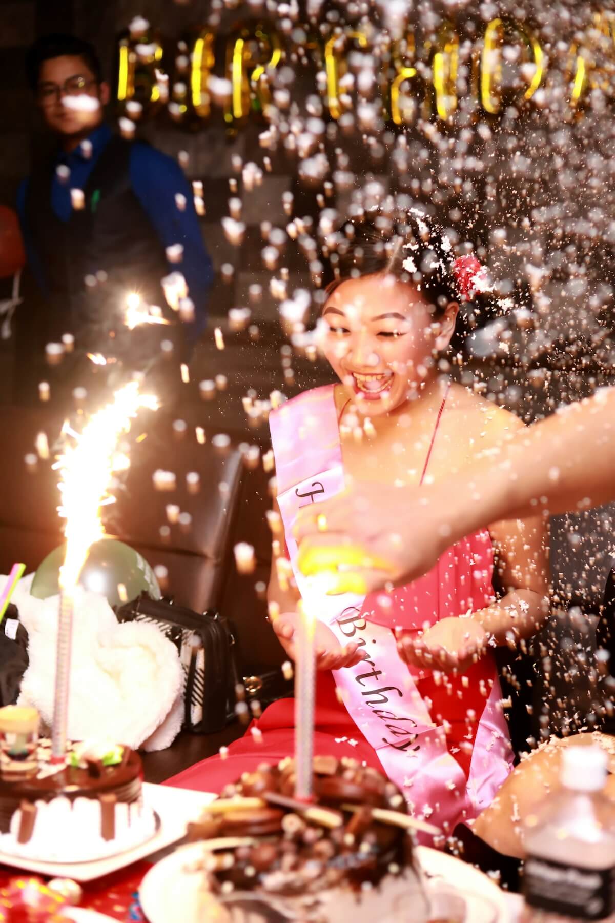 Unsplash: woman celebrating birthday with confetti and sparker cake by Sujan Khalifa