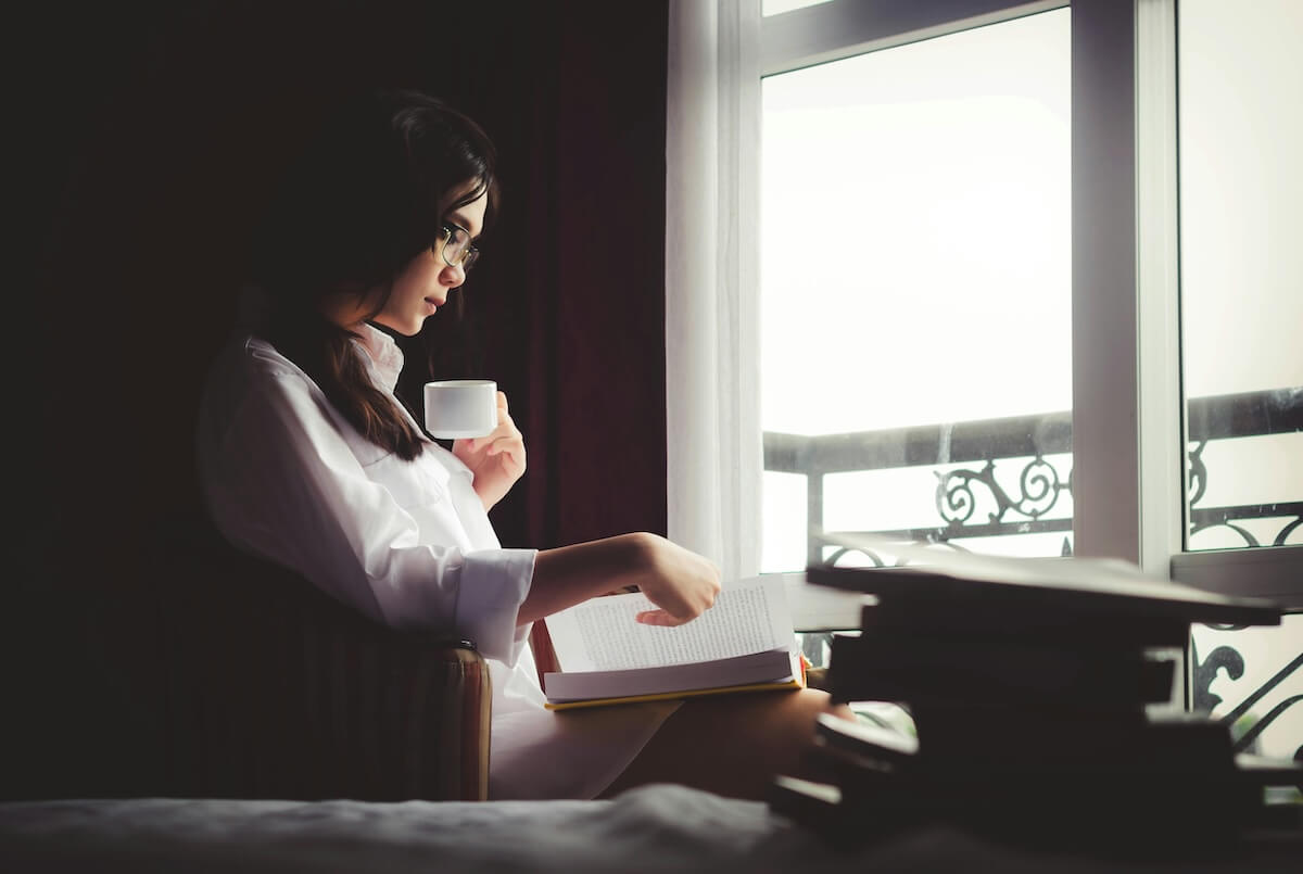 Unsplash: Cozy woman reading a book with coffee by Anthony Tran