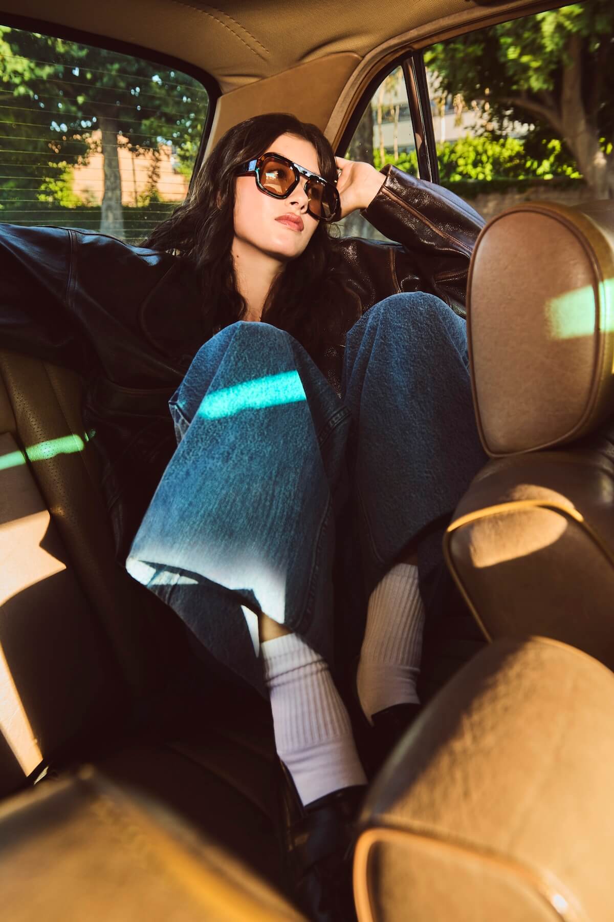Jade LeMac in leather jacket in back of car