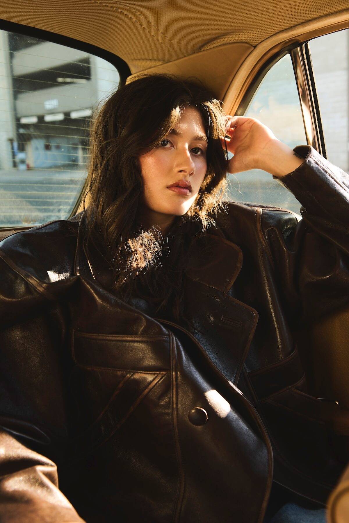 Jade LeMac in leather jacket in back of car