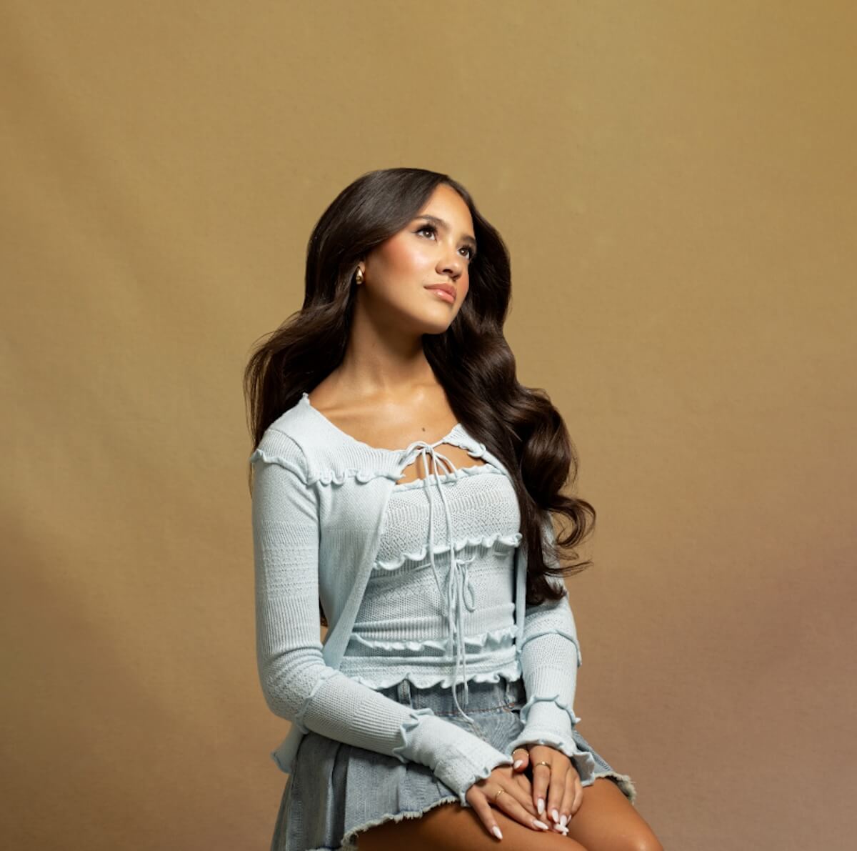 Singer-songwriter Liamani in blue frilly top and skirt